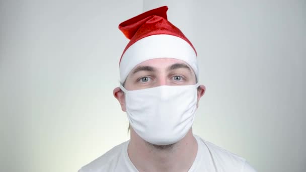 Troque o Papai Noel em máscara médica protetora em óculos de sol pixelados engraçados no fundo branco. Tempo de festa vívida, Feliz Ano Novo, Quarentena Feliz Natal, conceito de celebração . — Vídeo de Stock