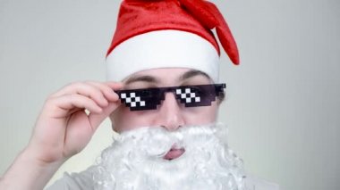 Beyaz arka planda komik pikselli güneş gözlüklü Tarz Noel Baba. Gangster, patron, cani hayatı. 8bit tarzı. Holly Jolly x Mas Noel. Harika büyükbaba. Parti zamanı, Mutlu yıllar, Mutlu Noeller