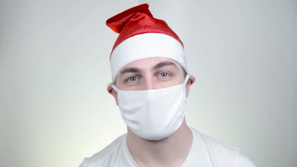 Swag Père Noël dans un masque médical de protection dans des lunettes de soleil pixellisées drôles sur fond blanc. Fête conviviale, Bonne année, Quarantaine Joyeux Noël, concept de célébration . — Video