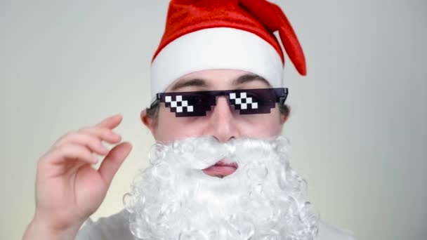 Swag Père Noël dans des lunettes de soleil pixellisées drôles sur fond blanc. Un gangster, un patron, un voyou. Style 8bit. Holly Jolly x Mas Noel. Cool grand-père. Fête, Bonne année, Joyeux Noël — Video