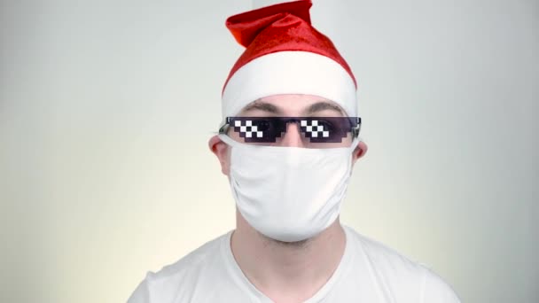 白い背景に面白いピクセル化されたサングラスで保護医療用マスクのスワッグサンタクロース。Covid Party time, Happy New Year, Quarantine Merry Christmas, celebration concept . — ストック動画