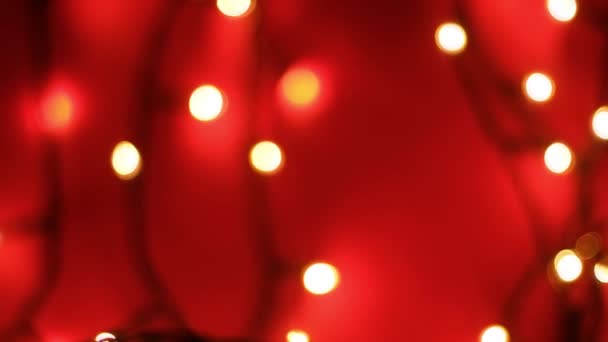 Abstracte wazige bokeh lichten op rode achtergrond. Kerstvakantie en nieuwjaarsvakantie licht — Stockvideo