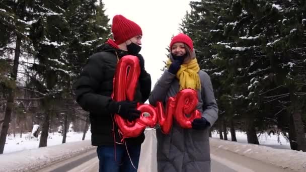 Några kyssar i skyddsmasker Coronavirus pandemi. Skyddsåtgärder på offentlig plats under epidemin. Säkerhet Covid St. Valentine helgfirande — Stockvideo