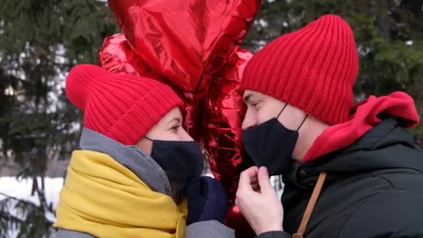 Några kyssar i skyddsmasker Coronavirus pandemi. Skyddsåtgärder på offentlig plats under epidemin. Säkerhet Covid St. Valentine helgfirande — Stockvideo