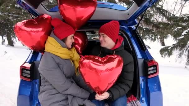 Loving guy and happy girl kissing on Valentines Day hiding behind heart shape balloon. St Valentines Day celebration, romantic relationships, sincere feelings and love concept. Happy couple. — Stock Video