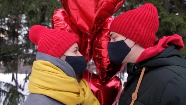 Couple kiss in protective masks Coronavirus pandemic. Protective measures in public place during epidemic. Safety Covid St. Valentine holiday celebration — Stock Video