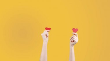 Kadın blogcu elinde küçük kırmızı kalbi sarı turuncu arka planda tutuyor. Sosyal ağdaki gibi. Sevgililer Günü, Uluslararası Kadınlar Günü, Aşk