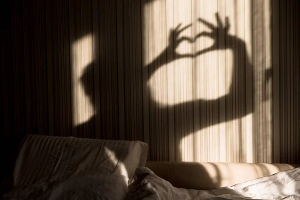 女人用手在墙上做心影。世界心理健康日，希望与爱。2月14日 — 图库照片