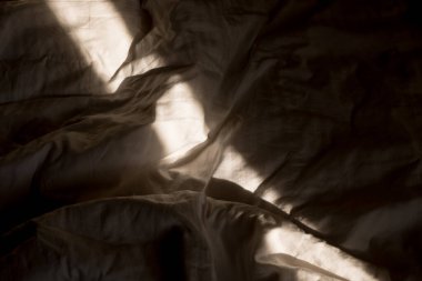 Güneş ışığı yatağa düşer. Sabah güneş pencereden içeri doğru ışıldar. Sıcak Güneş Işığıyla Yeni Gün.