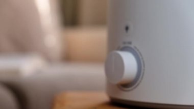 Kadın evdeki modern hava nemlendiricisini, aroma yağını açıyor. Bir evde yaşamanın rahatlığını geliştirmek, refahı arttırmak. Ultrasonik buhar teknolojisi.