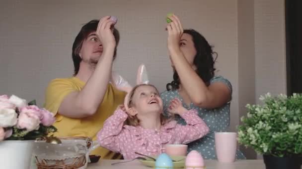 Happy Easter. Preparing family for Easter. Parents with child beating Easter eggs. Mother, father and daughter wearing bunny ears. Smiling faces. — Stock Video