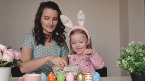 Wielkanoc, rodzina, wakacje i koncepcja dzieci. Matka i córka malują jajka. Szczęśliwa rodzina przygotowuje się do Wielkanocy — Wideo stockowe