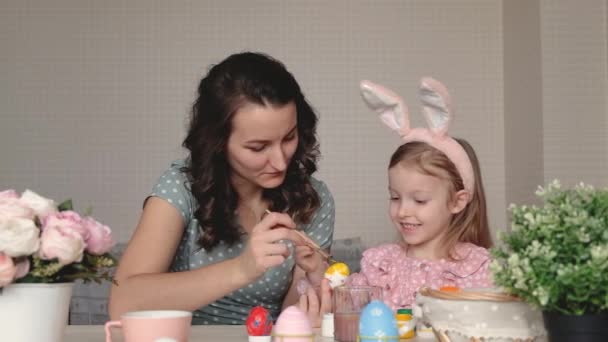 Paskalya, aile, tatil ve çocuk konsepti. Anne ve kızı yumurta boyuyor. Mutlu aile Paskalya için hazırlanıyor. — Stok video