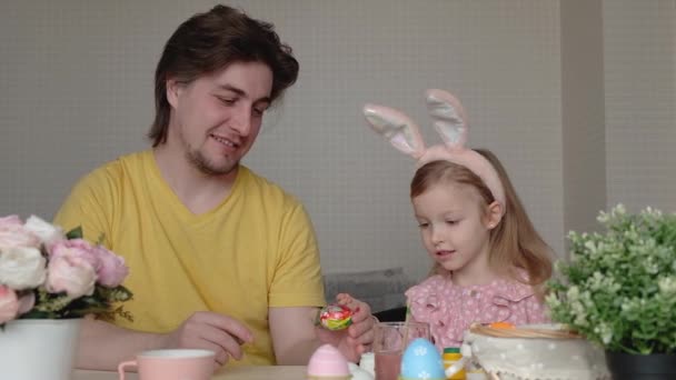 Concepto de Pascua, familia, vacaciones y niños. Padre e hija pintando huevos. Familia feliz preparándose para la Pascua — Vídeos de Stock