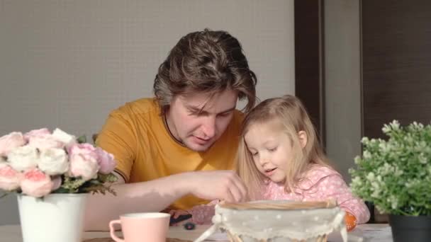 Familie, vakantie en kinderen concept. Vader en dochter schilderen in de keuken. Gelukkige familie — Stockvideo