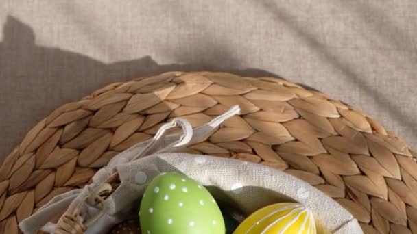 Великодні барвисті яйця в кошику на білому дерев'яному столі. Зі святом Великодня . — стокове відео