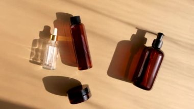 Doğal güzellik ürünleri paketi. Sabah ışıklarında pastel bej arka planda kahverengi cam şişeler. Eko kozmetik krem, cilt, yüz ve vücut için serum. Cilt bakımı, spa ve sağlık kavramı