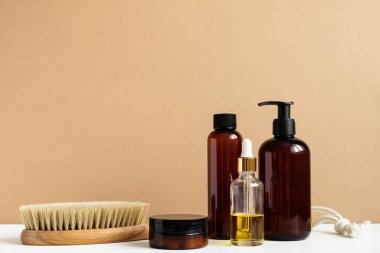 Vücut bakımı ve spa. Doğal güzellik ürünleri. Eko-krem, serum, cilt bakımı boş şişe. Kuru anti-selülit masajı için fırça. Düşük cam, yağlı kozmetik boru.