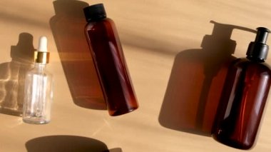 Doğal güzellik ürünleri paketi. Sabah ışıklarında pastel bej arka planda kahverengi cam şişeler. Eko kozmetik krem, cilt, yüz ve vücut için serum. Cilt bakımı, spa ve sağlık kavramı