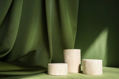 Geometrik formlarla soyut asgari sahne. Yeşil arka planda silindir podyumlar. Soyut arkaplan. Kozmetik kapsülleri göstermek için sahne. Vitrin, vitrin. 3d hazırlayıcı.