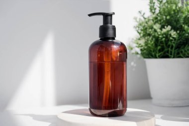 Brown glass bottle on white background in the morning rays of light. Eco cosmetic cream, serum for skin, face and body. Concept of skincare, spa and wellness center. Natural beauty products