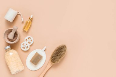 Vücut tedavisi ve spa kompozisyonu. Doğal güzellik ürünleriyle yatıyordu. Eko-krem, serum, cilt bakımı boş şişe. Kuru anti-selülit masajı için fırça. Düşük cam, yağlı kozmetik boru.