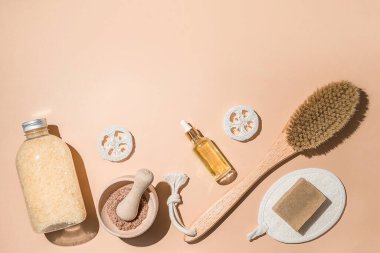 Vücut tedavisi ve spa kompozisyonu. Doğal güzellik ürünleriyle yatıyordu. Eko-krem, serum, cilt bakımı boş şişe. Kuru anti-selülit masajı için fırça. Düşük cam, yağlı kozmetik boru.