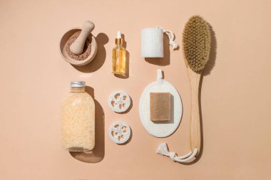 Vücut tedavisi ve spa kompozisyonu. Doğal güzellik ürünleriyle yatıyordu. Eko-krem, serum, cilt bakımı boş şişe. Kuru anti-selülit masajı için fırça. Düşük cam, yağlı kozmetik boru.