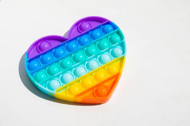 Stres önleyici oyuncağı patlat. Gökkuşağı duyusal kıpırdaması beyaz arka planda izole edilmiş. Yeni moda silikon oyuncak.