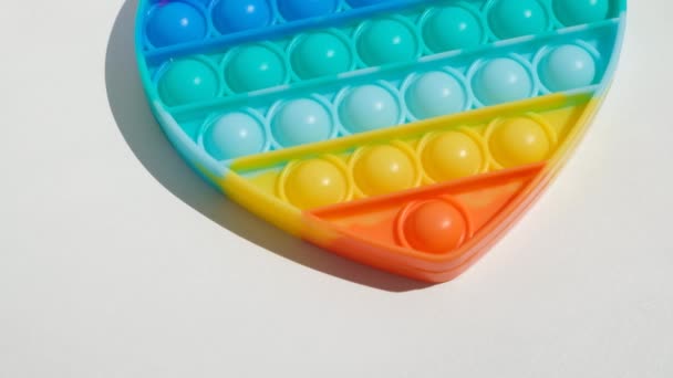 Antistress-Pop-it-Spielzeug. Regenbogen sensorische Fidget isoliert auf weißem Hintergrund. Neues trendiges Silikonspielzeug. — Stockvideo