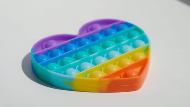 Antistress-Pop-it-Spielzeug. Regenbogen sensorische Fidget isoliert auf weißem Hintergrund. Neues trendiges Silikonspielzeug. — Stockvideo