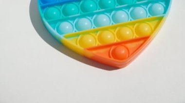 Stres önleyici oyuncağı patlat. Gökkuşağı duyusal kıpırdaması beyaz arka planda izole edilmiş. Yeni moda silikon oyuncak.