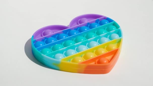 Antistress-Pop-it-Spielzeug. Regenbogen sensorische Fidget isoliert auf weißem Hintergrund. Neues trendiges Silikonspielzeug. — Stockvideo