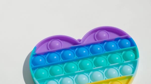 Antistress gooit het stuk speelgoed. Regenboog zintuiglijke fidget geïsoleerd op witte achtergrond. Nieuw trendy siliconen speelgoed. — Stockvideo
