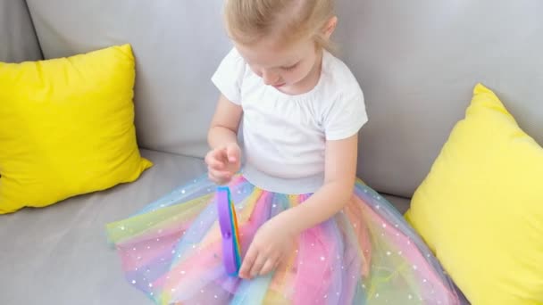 Antiestrés pop it toy. Chica jugando con el arco iris nerviosismo sensorial aislado sobre fondo blanco. Nuevo juguete de silicona de moda. — Vídeo de stock