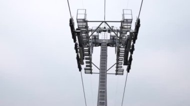 Dağ kayak merkezindeki asansör kabinleri. Bulutlu bir günde Hilghland Dağı 'nda kayak kaldırma halatı. Kayak teleferiği kablosu insanlarla dolu. Manzaralı, yokuş aşağı geniş bir manzara..