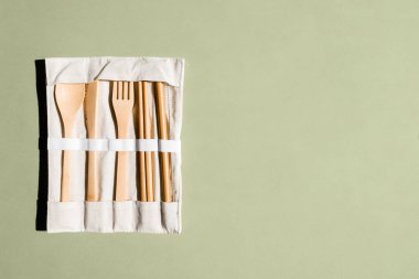 Yeşil arka planda çevre dostu bambu çatal bıçak seti. Sürdürülebilir yaşam tarzı. Plastiksiz konsept. Sıfır atık. Metin için yer