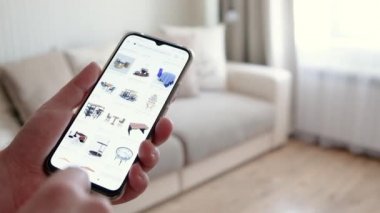 Adam geliştirilmiş gerçeklik tasarımı için akıllı telefon uygulaması kullanıyor oturma odası mobilyalarının tipini ve rengini seçmek için. İç Tasarım Gelecek Teknolojileri. Üç boyutlu çizim. Çevrimiçi alışveriş kavramı