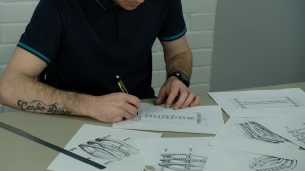 Craft goldsmith work. Portrait of young jeweler drawing a sketch of a new ring. Concept of: wedding, luxury, jewelry — Stock Video