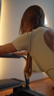 Modern bir stüdyoda, bir kadın atletizm ve ruhani denge ile yoga yapıyor, esneklik ve zarafet gösteriyor.