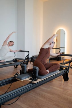 Modern bir stüdyoda, bir kadın atletizm ve manevi denge ile yoga yapıyor, esneklik ve zarafet sergiliyor.