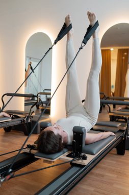 Reformcu bir kadın, kontrollü bacak daireleri çizerek temel bağlantıyı ve terapiyi vurguluyor.