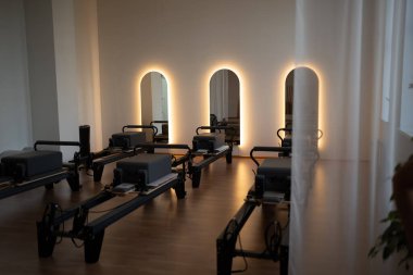 Huzurlu pilates alanı, minimalist pilates atölyesi yumuşak arka plan kemerleri ve güneş ışığıyla aydınlatılıyor.