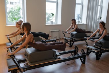Stüdyo yenilikçi sınıf dinamikleri, enerjik grup pilates, odaklanmış hareket ile reformcu oturum.