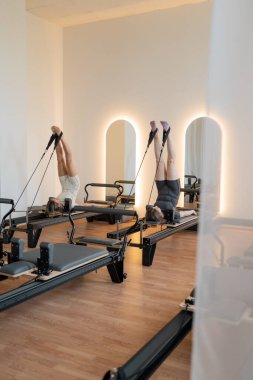 Aynalı sakin yenilikçi oda, sıcak ışıklandırmalı ve ahşap zeminli huzurlu pilates alanı