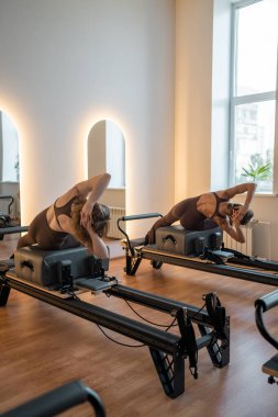 Huzurlu stüdyo ortamında reform egzersizi sırasında denge ve hizalamaya odaklanan eğitmen