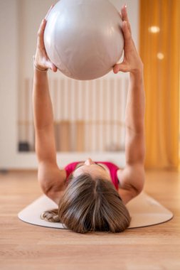 Modern pilates stüdyosunun altında denge toplarıyla temel egzersizler yapan bir kadın. Yüksek kalite fotoğraf