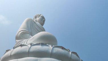 Nefes kesici bir manzara, açık mavi gökyüzüne güzel bir şekilde yerleştirilmiş büyük beyaz Buda heykelini gözler önüne seriyor.