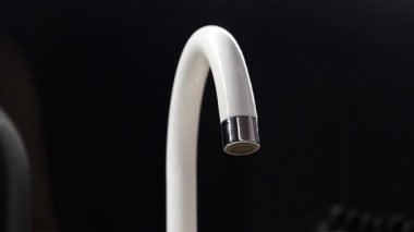 Mutfak musluğunu pislikten temizliyorum. Mutfak musluğunu süngerle silen kadın ellerine yakın çekim. Mutfağı temizliyorum. Ev hanımı musluğu temizliyor.