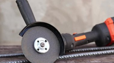 Ahşap bir masanın üzerinde kablosuz açı öğütücü. Tamir ve inşaat için bir araç. Kablosuz açı öğütücü yakın plan. Ülkedeki araç.